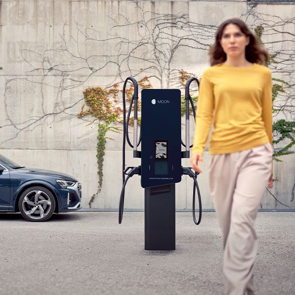 Woman walks in front of a charging station